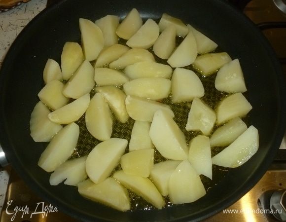 В большой сковороде разогреть масло. Уровень масла должен быть хороший, до 0,5 см. Выложить картофель. Жарить, помешивая, до золотистой корочки.