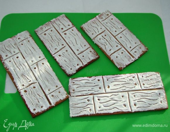 Смешать яичный белок, сахарную пудру и несколько капель лимонного сока в однородную белую массу — айсинг. Намазать айсинг на «дощечки» и дать хорошо засохнуть. 