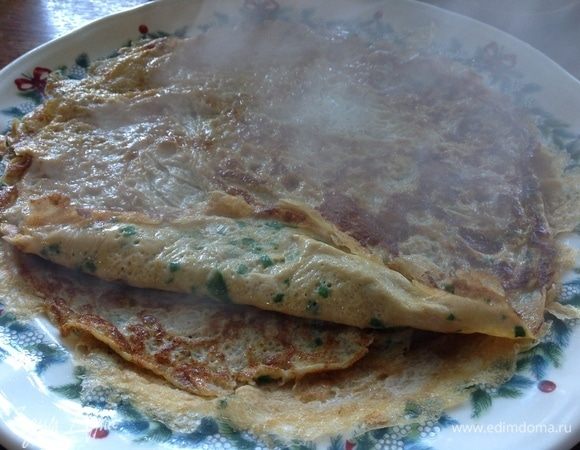 Теперь поддеваем его по кругу лопаткой, и просто переворачиваем сковородку вниз на блюдо, чтобы блин выпал на блюдо, аккуратно его расправляем и жарим вторую порцию омлета, и так всего, повторюсь, 3 омлетных тонких блина.