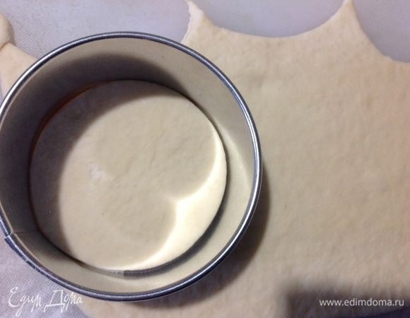 Теперь делим на 2–3 части, каждую часть раскатываем в пласт толщиной 3–4 мм и выдавливаем круги, у меня диаметр круга был 8 см. Оставшиеся обрезки теста я обминала, снова раскатывала и выдавливала круги.
Выкладываем начинку, закрываем пирожок по шву и кладем швом вниз на пергамент на противень на небольшом расстоянии друг от друга. Они немного слипнутся между собой после выпечки, это не страшно, отделяются они легко.
У меня вышло 2 средних 30*20 см противня пирожков, 31 штука.
Оставляем противни с пирожками на расстойку, накрыв их полотенцами, на 40 минут.