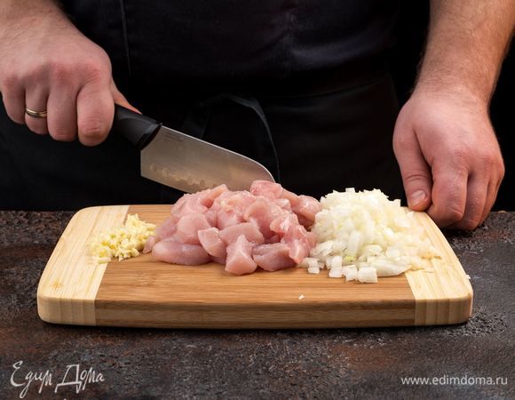 Мелко нарежьте лук и чеснок. Куриное филе промойте, обсушите бумажными полотенцами и мелко нарежьте.