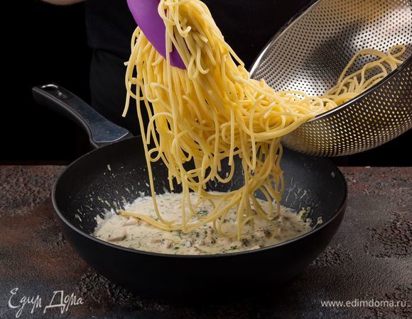 Выложите спагетти на сковороду к курице.