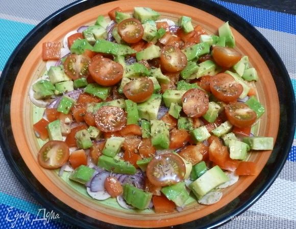 Сверху лука раскладываем помидоры черри, разрезанные пополам, кубики авокадо и сладкого перца. Приправляем солью, перцем, сахаром, приправой. Сбрызнуть лимонным соком и оливковым маслом.