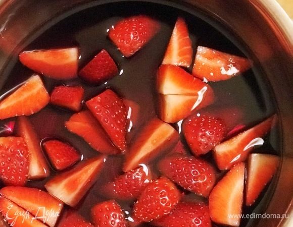 Для соуса  вымыть 150 г клубники,  разрезать на 2–4 части. Выложить ягоды в небольшую кастрюлю, влить вино и поставить на огонь.