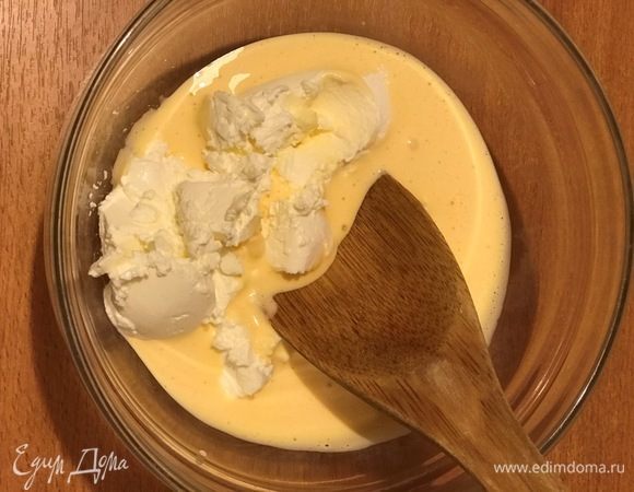 Половину маскарпоне выложить к желткам и все перемешать деревянной ложкой, добавить оставшийся сыр и еще раз вымешать.