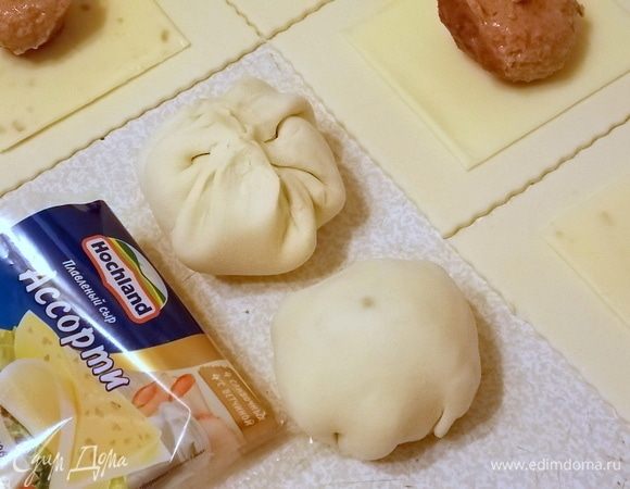 Соединить противоположные концы теста и защипать. Перевернуть и покатать в ладошке до формы шара. Положить в смазанный противень или коврик для выпекания. Смазать слегка взбитым яйцом.