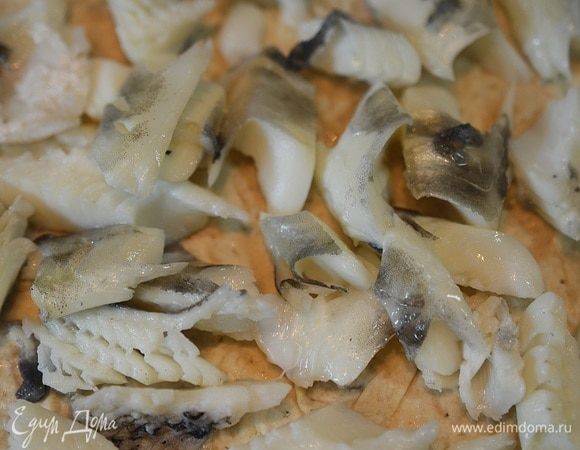 Рыбу разберите на кусочки и выложите следующим слоем.