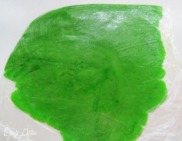 Раскатать тесто между двумя слоями пергамента (у меня пищевая пленка) до толщины 2-3 мм. Если сделать толще, пирожные могут не подняться, либо корочка некрасиво треснет. Убрать заготовку в морозилку.