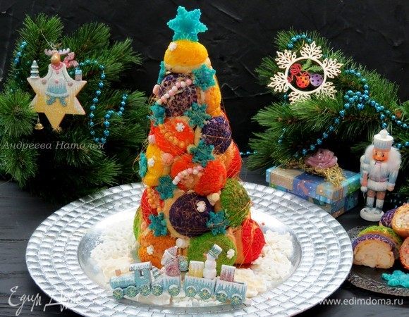 Затем аккуратно извлекаем затвердевший конус из бумажной оболочки. Ставим на блюдо и украшаем по своему желанию. Я сделала классические карамельные нити, украсила сахарными бусинами и снежинками из марципана.