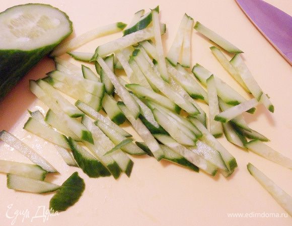 Огурец нарезать тонкой соломкой. Переложить горкой на общее блюдо с пожеланием ровной дороги к богатству.