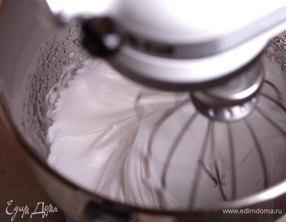 Сироп достиг температуры 117°С. Начинаем лить его по стенке чаши тонкой струйкой во взбивающиеся белки. Масса начнет быстро густеть.