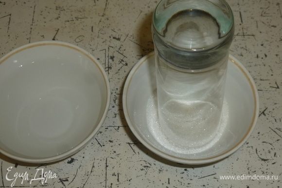 Взять 2 мисочки, в одну налить воду, в другую насыпать сахар. Обмакнуть краешек стакана в воду, затем в сахар. Покрутить намного стакан в сахаре, чтобы украсить бокал. Аккуратно налить коктейль в стакан.