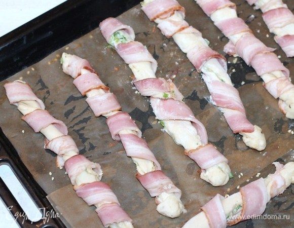 Противень застилаем бумагой для выпечки и смазываем растительным маслом. Выкладываем рулетики на противень и отправляем в разогретую до t 40°С духовку на 15 минут или до увеличения теста в 2 раза.