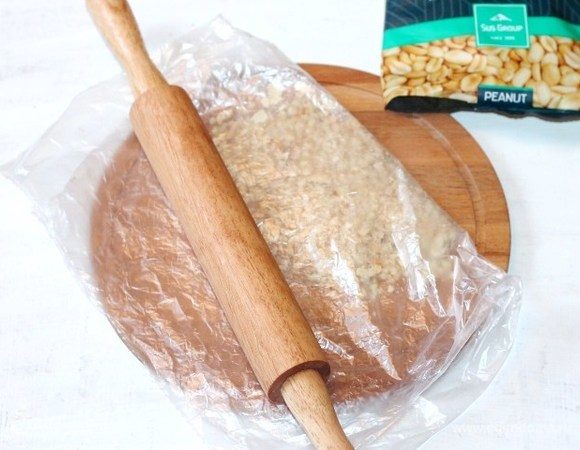 Кладем обжаренные орехи в пакет и измельчаем скалкой. Величина помола по вашему вкусу.
