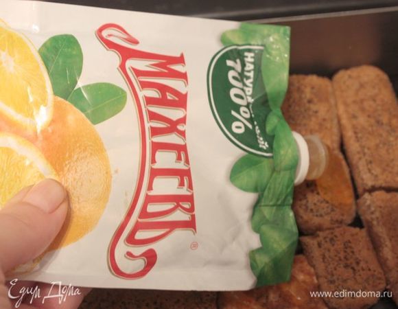 Натрите шоколад на мелкой терке. Лучше всего предварительно положить шоколад в морозильник, а затем доставать небольшими партиями и быстро тереть.
Начинаем собирать тирамису! Возьмите савоярди, обмакните их в кофе и выложите в основании формы. Сверху тонким слоем распределите апельсиновый джем ТМ «МахеевЪ».