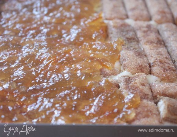 Посыпьте джем тертым горьким шоколадом и выложите крем. Разровняйте и повторите в таком же порядке. 