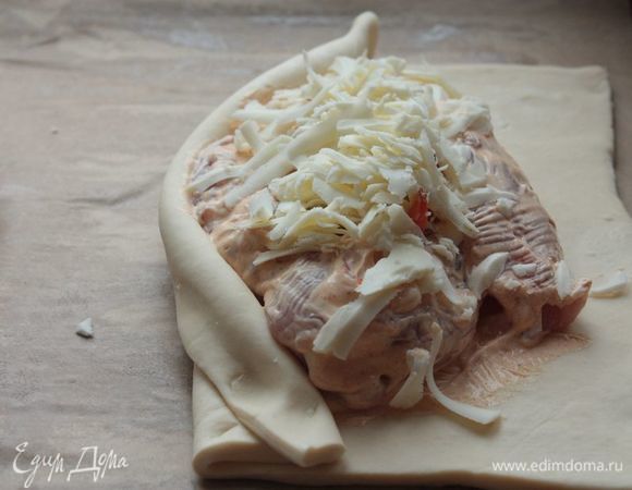 Поверх выложите куриную грудку, надрежьте ее посредине (в самом толстом месте), чтобы получился кармашек. Смажьте ее также соусом с паприкой. В кармашек у нас пойдет перец — обильно присыпьте его сыром. 
Подогните тесто с каждой стороны, чтобы получилась «лодочка». Убедитесь, что края теста крепко держаться, иначе при запекании они разойдутся!