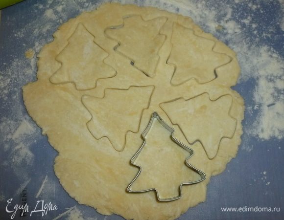 Тесто раскатать до толщины 5-7 мм. Формочками вырезать печенье, перенести на застеленный пергаментом противень. Смазать верх желтком и присыпать коричневым сахаром.