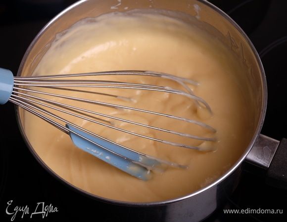 Молоко довести до кипения. Тонкой струйкой влить молоко в яично-мучную смесь, не переставая взбивать (на минимальной скорости миксера). Перелить смесь обратно в ковш и поставить на средний огонь. Варить крем, помешивая венчиком, до получения густой однородной массы. 