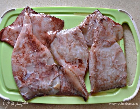 Кальмары (3 тушки) разморозить, очистить, хорошо промыть в проточной воде и отварить 1-2 минуты в подсоленной воде.