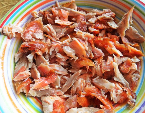 Копченый норвежский лосось отделить от костей и распотрошить на кусочки.