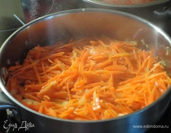 В глубокой сковороде разогреть масло и обжарить лук до золотистого цвета. Добавит морковь и обжаривать не более минутки. Влить вино, дать покипеть пару минут.