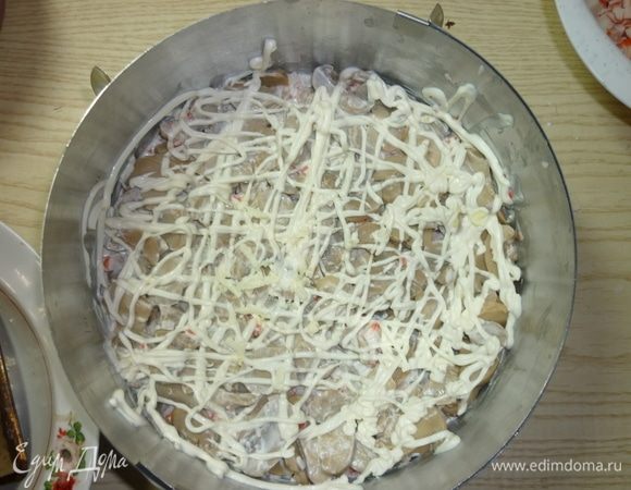 Третьим слоем укладываю грибы. У меня грибы резанные, поэтому дополнительной нарезки не требуют. Также делаю сетку из майонеза.