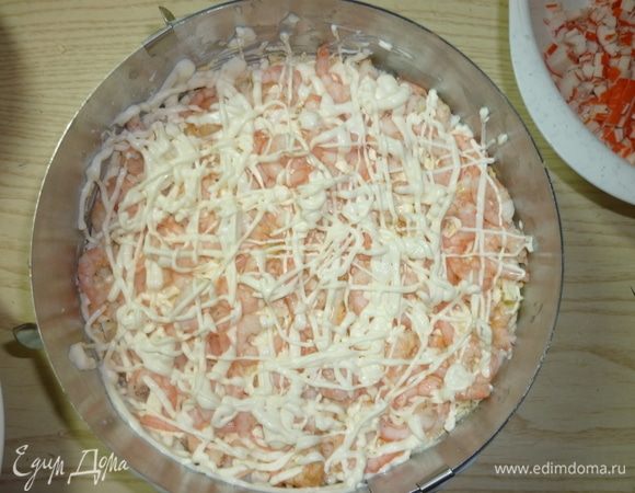 Пятым слоем выкладываю креветки и делаю майонезную сеточку.