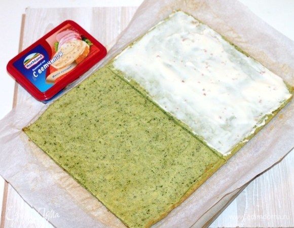 Остывший корж разрезаем на две равные части. Одну часть смазываем плавленным сыром Hochland. 