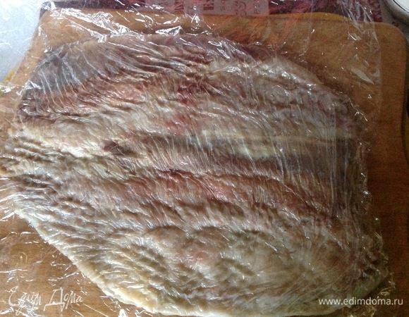 Накрываем второй пленкой и отбиваем молоточком для битков. Сравниваем все выпуклости, после отбивания селедка становится как одно целое и увеличивается в ширину.