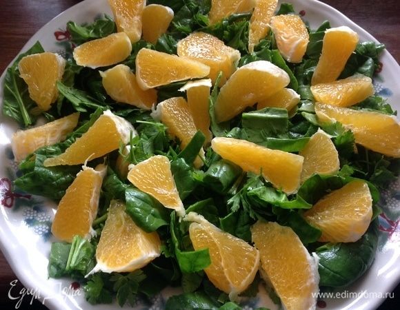 Зелень помыть, фрукты очистить от кожуры. На плоское большое блюдо, крупно порезать шпинат и петрушку, поверх порезанный апельсин.