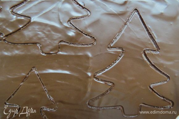 Оставшийся шоколад нанести шпателем на силиконовой коврик, дать стабилизироваться, вырубками вырезать силуэты елочки, а из белого шоколада — силуэт оленя.