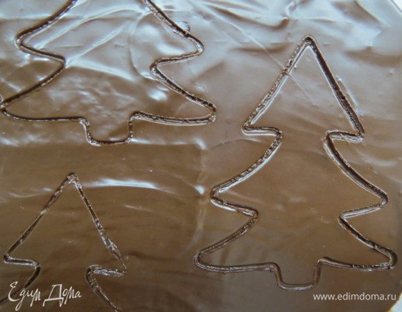 Оставшийся шоколад нанести шпателем на силиконовой коврик, дать стабилизироваться, вырубками вырезать силуэты елочки, а из белого шоколада — силуэт оленя.