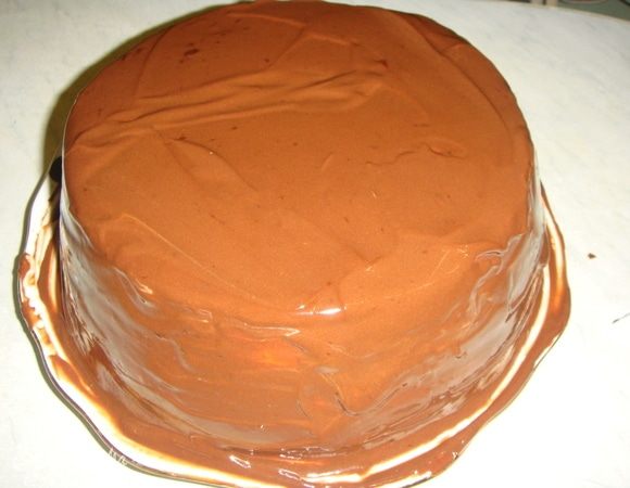Шоколад мелко порубить, сложить в маленький сотейник, влить сливки и, постоянно помешивая, растопить шоколад. Полить охлажденный торт шоколадной глазурью и украсить по желанию.