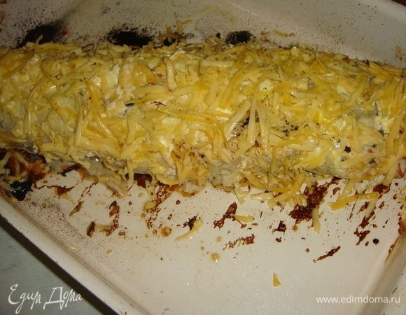 С рулета аккуратно снять нитки. Посыпать рулет натертым на крупной терке сыром и запекать ещё 10-15 минут, до золотистой корочки.