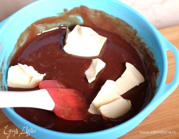 Масло разделить на 4 части и добавить в горячую шоколадную эмульсию, перемешивать до полного растворения масла.