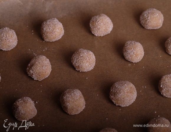 Духовку разогреть до 180°С.
От теста отщипывать кусочки теста, скатать из них шарики, обвалять в ванильном сахаре и выложить на пергамент.
