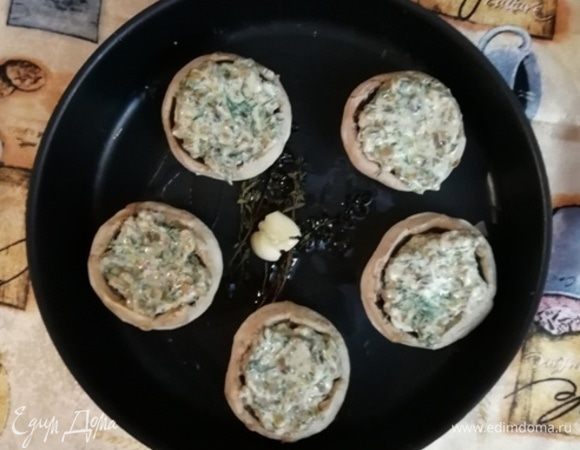 Уложить шляпки в противень. В шампиньоны уложить начинку. Запекать в разогретой до 200°С духовке в течении 20 минут.