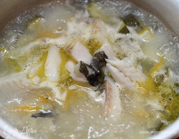 Затем бульон процедим, рыбу разберем на кусочке. Бульон на небольшой огонь. Кусочки рыбы вернем в бульон. Сюда же добавим копченый лосось.