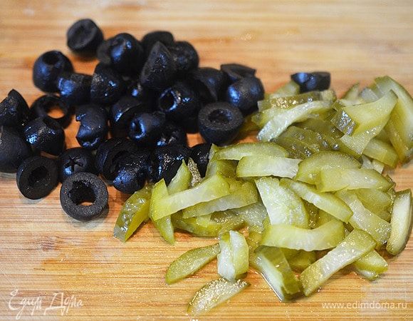 Маслины разрежем пополам, огурцы соломкой.