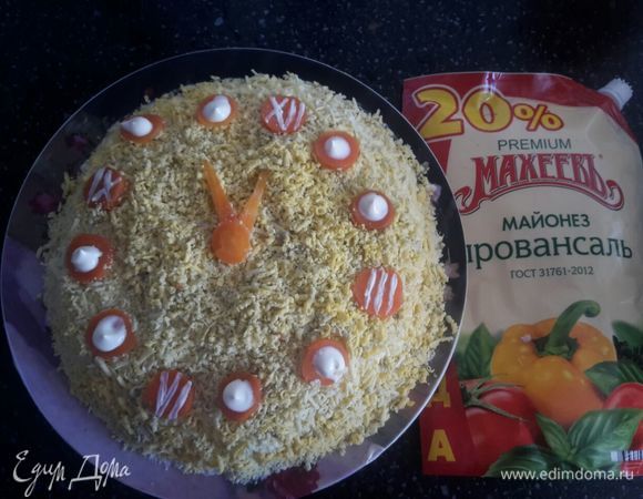 Следующий слой: желтки натереть на терке. Из моркови сделать стрелки и цифры для часов. Салат готов. Приятного аппетита.