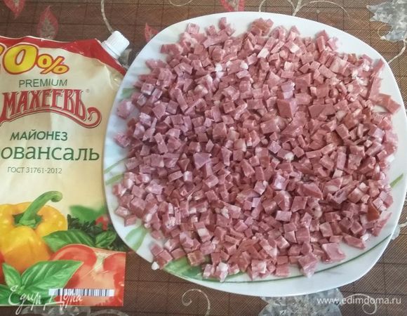 Колбаску режем мелким кубиком.Выкладываем первый слой, смазываем майонезом.