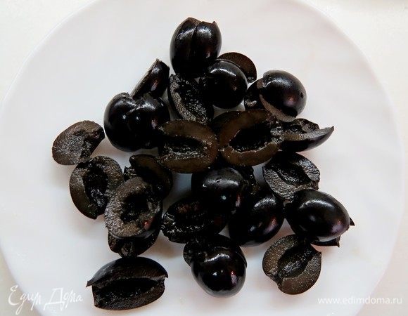 Маслины разрезать пополам. 