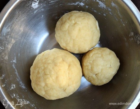 Постепенно введите муку по полстакана, вымешивая сначала ложкой, а затем разминая руками до формирования шара. Сформируйте 2–3 шара, заверните в пленку и поместите в морозилку на час.