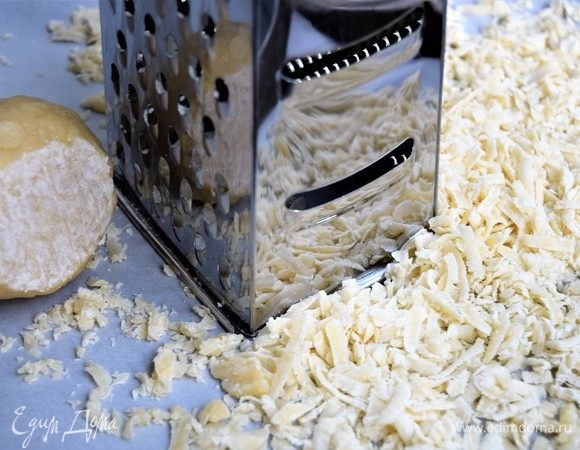 Разогрейте духовку до 170°C. Пока духовка нагревается, на крупной терке натрите тесто из морозилки ровным тонким слоем на лист для запекания с пергаментной бумагой. Удобно запекать тесто в два приема.