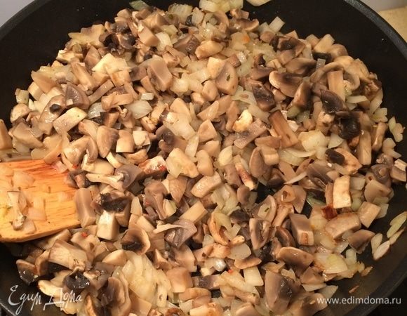В сотейнике разогреть немного растительного масла. Лук (оставшиеся 2 шт.) порезать мелким кубиком, обжарить до золотистого цвета. Добавить грибы и жарить, пока они не станут покрываться золотистой корочкой. Посолить. Начинку немного остудить.