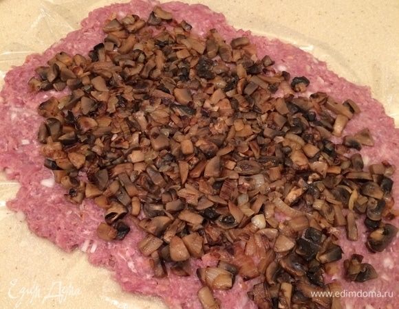 Сверху выложить половину начинки, распределить равномерно по фаршу.