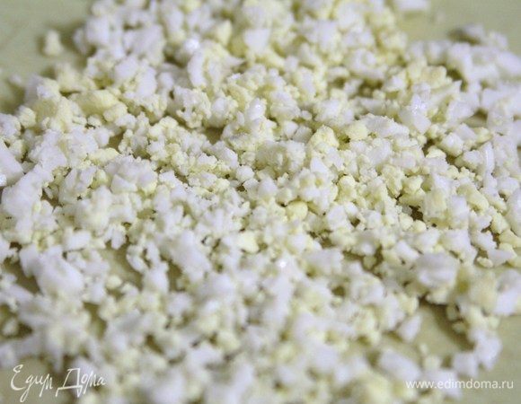 Яйца нарезать мелкими кубиками и добавить следующим слоем.