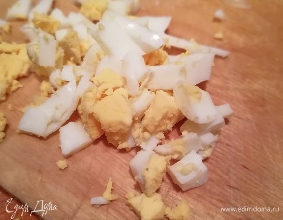 Оба яйца сварить вкрутую, затем одно почистить и нарезать вдоль кружками.  Второе почистить и мелко порубить. 