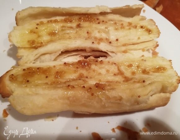Хлеб разрезать сбоку вдоль пополам, не прорезая до конца, развернуть и смазать обе половины заправкой.